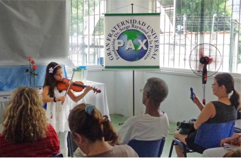 Niña toca violín a público en la Ciencia del Vivir